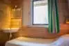 Villa vakantiehuisje 6 persoons slaapkamer met de 2 boxpringbedden los van elkaar met zicht op het bed onder het raam en aan het voeteneinde in de hoek een wastafel vakantiepark Tjermelan Oosterend Terschelling