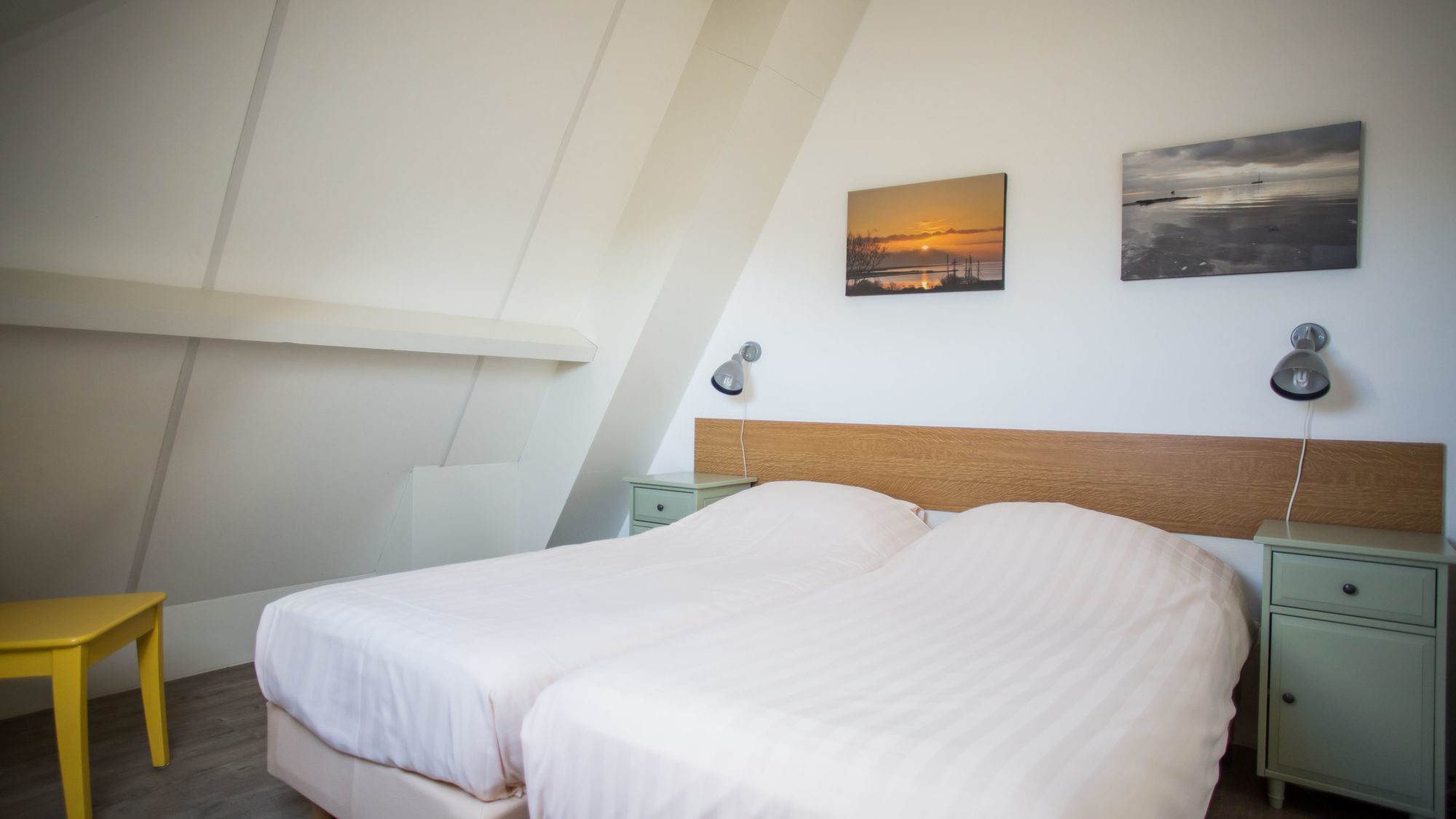 Schuin dak en lits jumeaux nachtkastje leeslampje wandfoto s Studio etage Hotel Tjermelan Terschelling Studio etage Hotel Tjermelan Terschelling